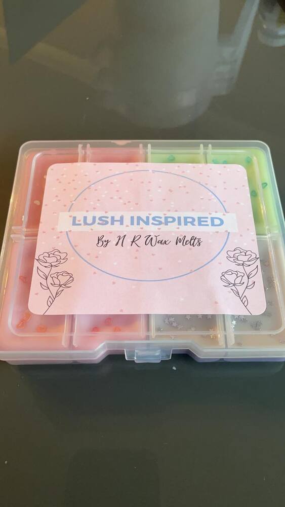 Wax melt sample box with a pastel logo label on its clear lid